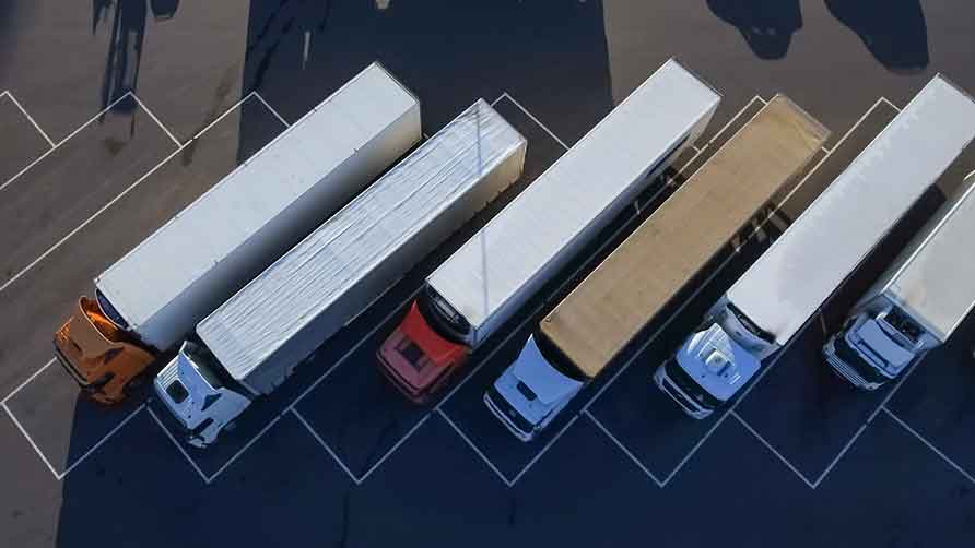 Zdjęcie z lotu ptaka pokazuje nowe ciężarówki ustawione na parkingu.
